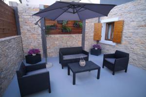 un patio con sillas, una mesa y una sombrilla en Apartments Hedona en Pula