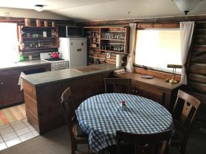 eine Küche mit einem Tisch, einem Kühlschrank und einer Theke in der Unterkunft La Posada Pintada in Bluff