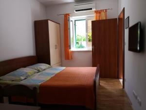 a bedroom with a bed and a window at Apartments Jaksic in Postira