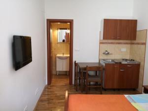 cocina con mesa y fregadero y TV en Apartments Jaksic, en Postira
