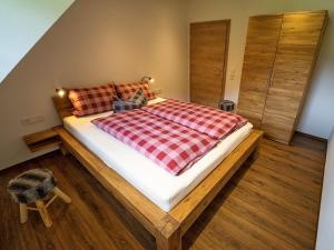 OberwolfachにあるMartinhansenhofのベッドルーム1室(チェック入りの毛布付きのベッド1台付)