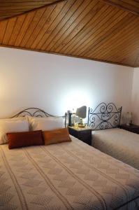 a bedroom with a large bed with a wooden ceiling at Casa Do Carvalho in Viatodos