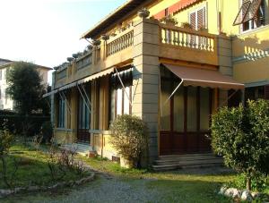 ein gelbes Haus mit Balkon darüber in der Unterkunft B&B Antica Piazza dei Miracoli in Pisa