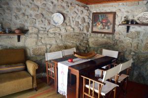 a dining room with a table and a stone wall at Casa Do Carvalho in Viatodos