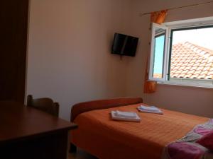 Habitación de hotel con cama y ventana en Apartments Jaksic, en Postira