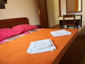 a bed with two white towels on top of it at Apartments Jaksic in Postira