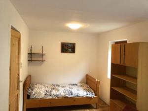 - une petite chambre avec un lit et une étagère dans l'établissement Szent Ilona Vendégház, à Monoszló