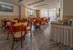 a restaurant with tables and chairs in a room at Dimitris Paritsa Hotel in Kos