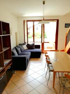 a living room with a couch and a table at Appartamento Orchidea Garda in Garda