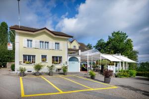 a building with a parking lot in front of it at Hallwil Swiss Quality Seehotel in Beinwil