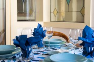 a table with blue plates and wine glasses on it at Venice Heaven Apartments San Marco, a stone's throw away from San Marco Square in Venice
