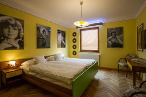a bedroom with a bed and pictures on the walls at Retro hotel Garage in Ostrava
