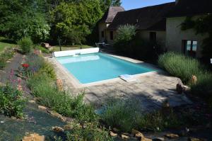 a swimming pool in a yard next to a house at Les Deux Tours in Siorac-en-Périgord