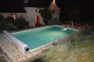 a swimming pool in a yard at night at Les Deux Tours in Siorac-en-Périgord