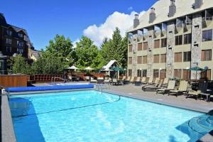 a large swimming pool in front of a hotel at Executive Inn Whistler in Whistler