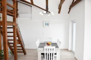 un comedor blanco con una mesa y sillas blancas en Apartmani Niko 05, en Zadar