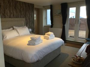 a hotel room with a bed with towels on it at The Sail Loft in Southwold