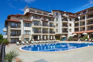 un hotel con piscina frente a un edificio en Relax Holiday Complex & Spa, en Sunny Beach