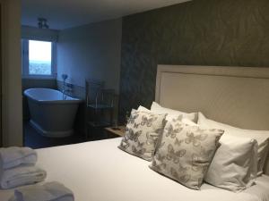 a bedroom with a bed and a bathroom with a tub at The Sail Loft in Southwold