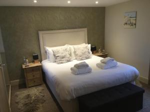a bedroom with a large bed with towels on it at The Sail Loft in Southwold