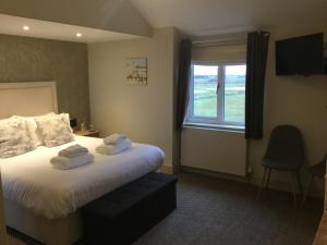a hotel room with a bed and a window at The Sail Loft in Southwold