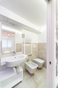 a white bathroom with a sink and a toilet at Ca' de la Fonte - WENICE Deep Culture in Venice
