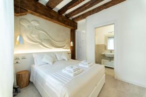 a bedroom with a white bed and a bathroom at Ca' de la Fonte - WENICE Deep Culture in Venice