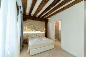 a bedroom with a white bed in a room at Ca' de la Fonte - WENICE Deep Culture in Venice