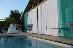 una piscina junto a una casa con patio en Buddha Bleu en Sainte-Luce