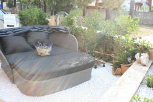 a couch sitting in a garden with plants at Apartments Villa San Antonio in Slatine