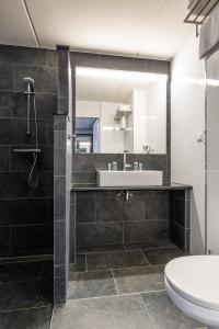 a bathroom with a sink, toilet and bathtub at Best Western Plus Amsterdam Airport Hotel in Hoofddorp