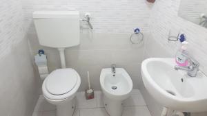 Un baño blanco con inodoro y lavabo. en B&B MIRAGLIA, en Nápoles 20 fotos más