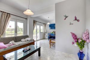 a living room with a couch and butterflies on the wall at Istira in Possidi
