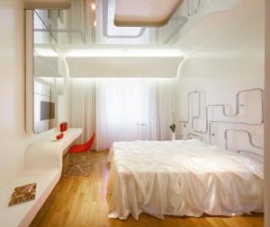 a bedroom with a white bed and a desk at Hotel Aurora in Merano