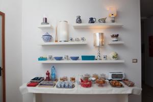 a white table with plates and bowls on shelves at B&B Night&Day in Reggio Calabria