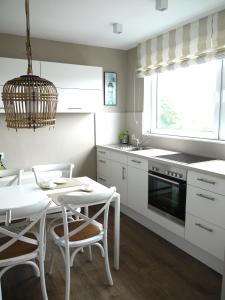 a kitchen with a table and a white table and chairs at Leuchtturmblick in Wangerooge