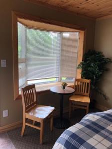 a bedroom with a table and two chairs and a window at Noble Motel in Norland