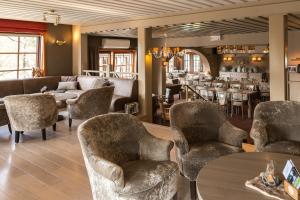 een lobby met stoelen en tafels en een bar bij Hostellerie d'Inzepré in Barvaux