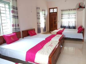 three beds in a room with red and white sheets at Lung Ho motel in Làng Cac