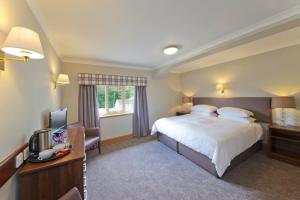 um quarto de hotel com uma cama e uma televisão em Tyndrum Lodges em Tyndrum