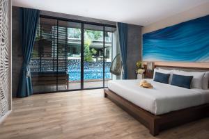 a bedroom with a large bed and a large window at Idyllic Concept Resort in Ko Lipe