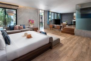 a bedroom with a large bed and a living room at Idyllic Concept Resort in Ko Lipe