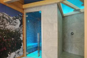 um chuveiro com uma porta de vidro na casa de banho em TOURING HOTEL & SPA em Edolo