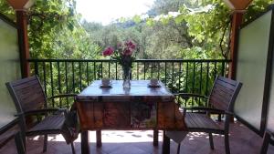 a table with chairs and a vase of flowers on a balcony at Dakis Studios in Keri