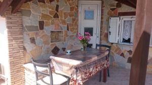 a table and chairs in front of a stone wall at Dakis Studios in Keri +44 photos
