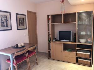 ein Wohnzimmer mit einem Tisch und einem TV in der Unterkunft Apartamento & sea view in Alicante