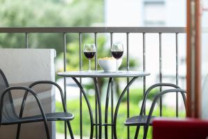 two glasses of wine sitting on a table on a balcony at Casa Carla in Nago-Torbole