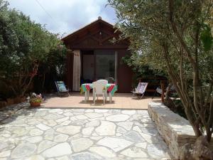 un patio con sedie e tavolo di fronte a una casa di Il Rustico di Pino a Custonaci