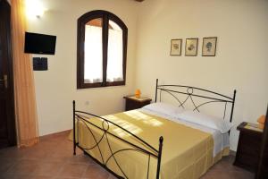 1 dormitorio con cama, ventana y TV en Agriturismo l'Olivo, en Calatafimi