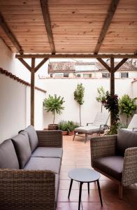 a patio with couches and tables and a wooden ceiling at Mante House - Malasaña Design in Madrid
